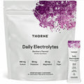 A white stand-up pouch of THORNE Daily Electrolytes, blackberry flavored, shown with a small matching single-serve stick pack beside it on a plain white background.